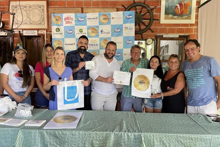 Pessoas recebendo o certificado de ilha inclusiva do secretario Rogerio Carboni e do Coordenador Felipe Braga Cortes.