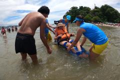 Mulher sendo conduzida na cadeira anfibia no mar.
